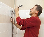 a handyman installs a low flow showerhead